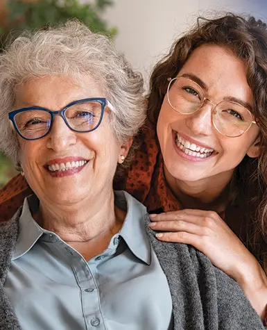 Grandmother and granddaughter smiling together, showing their close bond and enjoying a joyful moment.